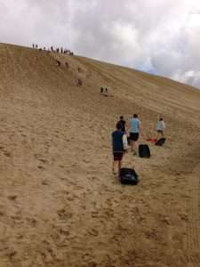Tobogganing down the sand dunes, just off 90-Mile Beach. It's a steep climb up--and a fast, sandy ride down! Did it 3 times. Kiwi As.